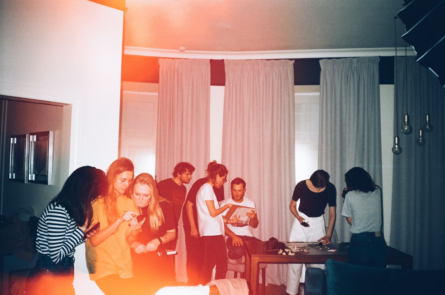 A group of friends enjoying a casual indoor gathering with a warm ambiance.