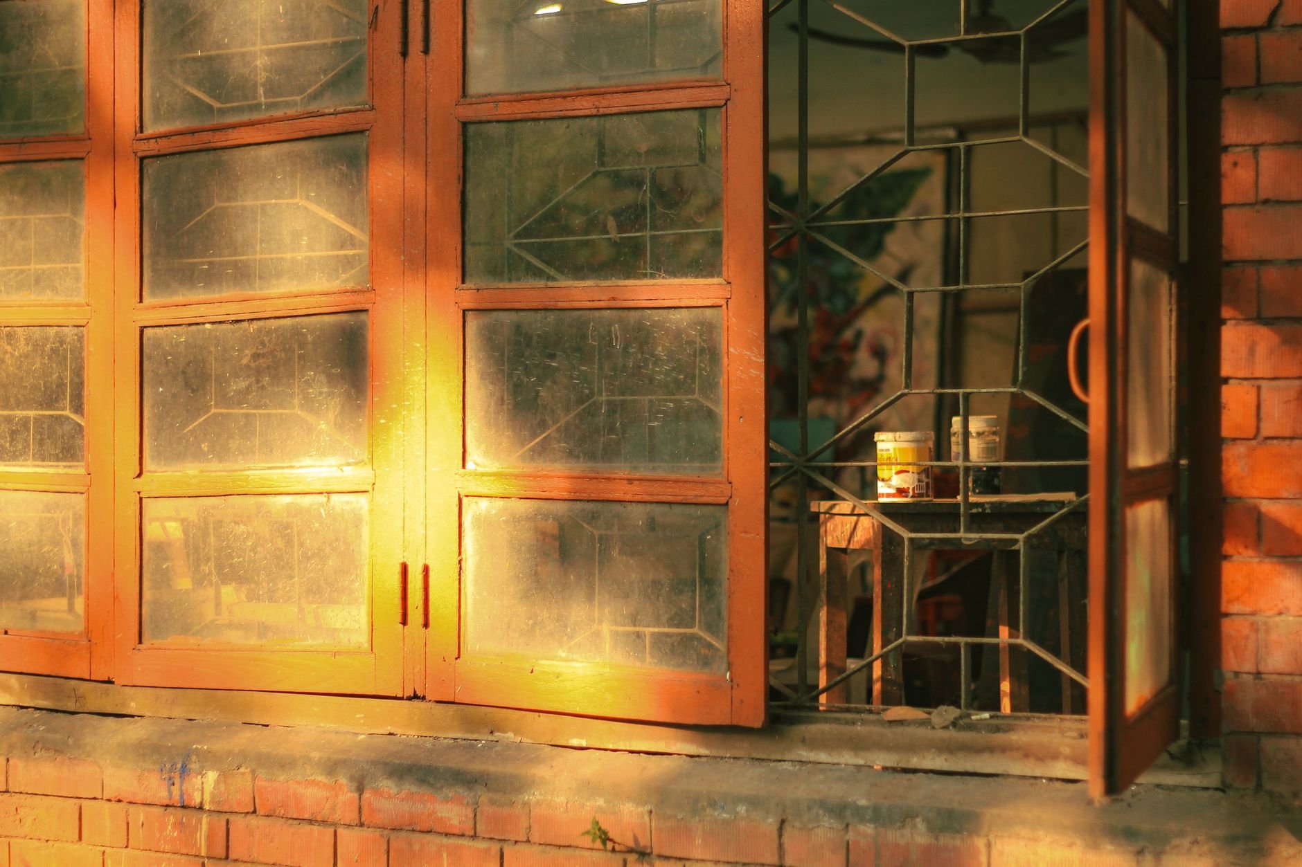 A sunlit window in an art studio with warm, golden lights creating a serene ambiance.